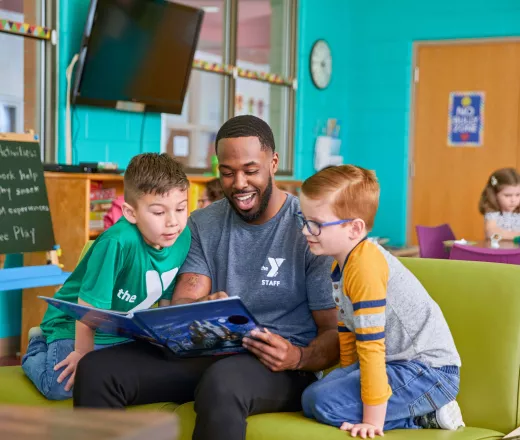 Adult reading a book to children at the YReads program
